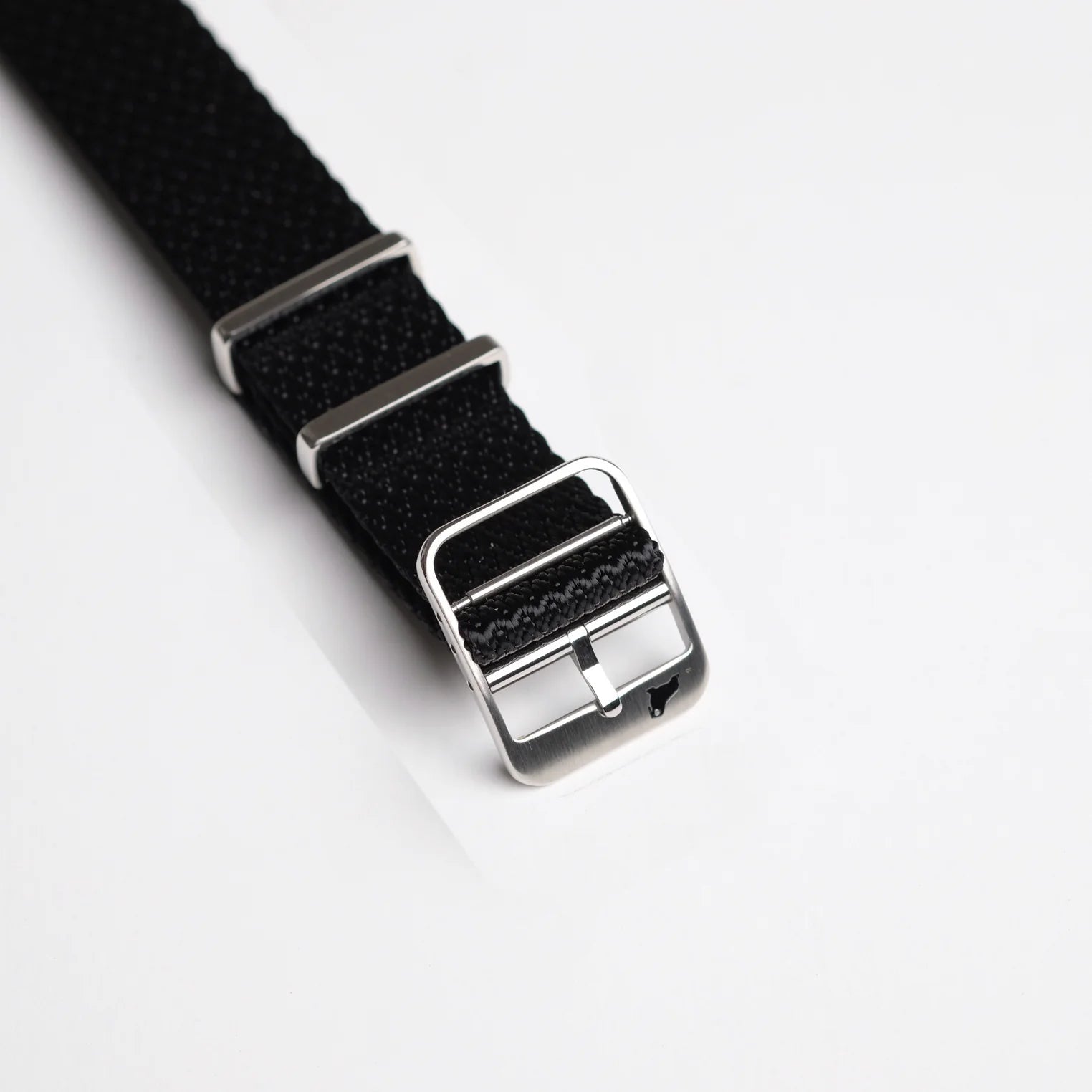 Close-up of the Herringbone Twill in Artillery Black watch band from RSM Watch Strap, with a polished silver buckle and loops.