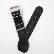 RSM's Herringbone Twill Artillery Black NATO strap with a silver buckle rests on a white surface, featuring metal loops.