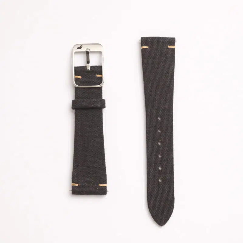 The Black Coal Fine Canvas watch strap by RSM Watch Strap, made from Japanese canvas, features a silver buckle, edge stitching, multiple adjustment holes, and quick-release spring bars.