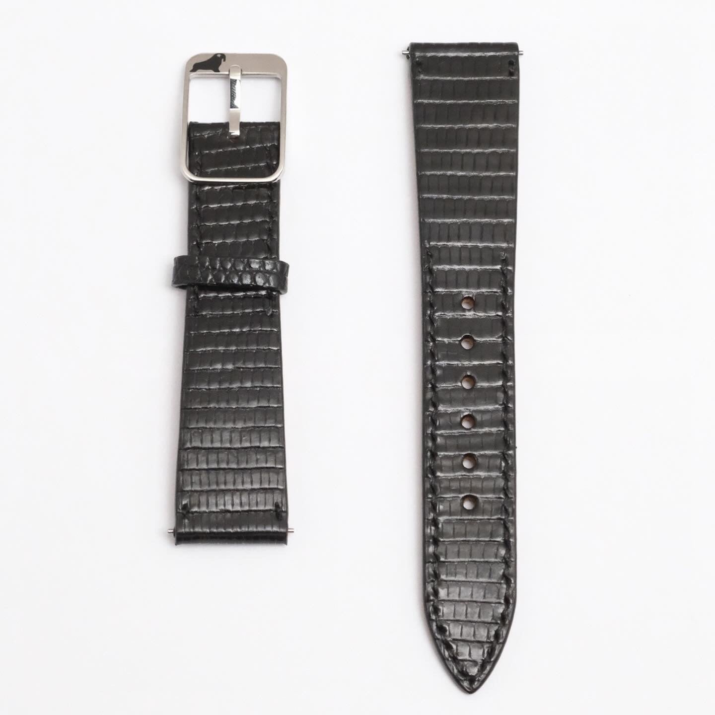 Two dark, textured RSM Spanish lizard straps on a white background: left with metal buckle, right with multiple adjustment holes.