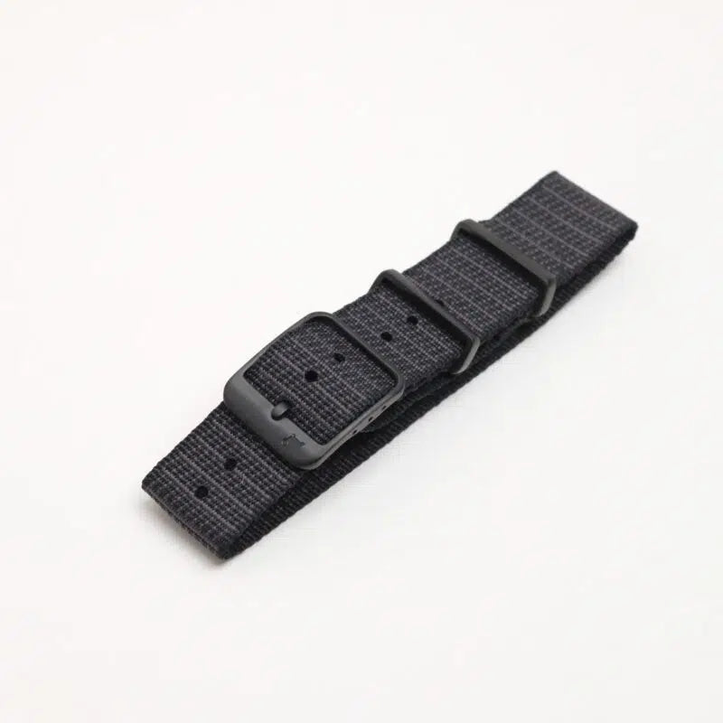 Single Pass X-Hatch Watch Strap in Black, made of textured polyester with black metal buckle, adjustment holes, and quick-release spring bars, on white.