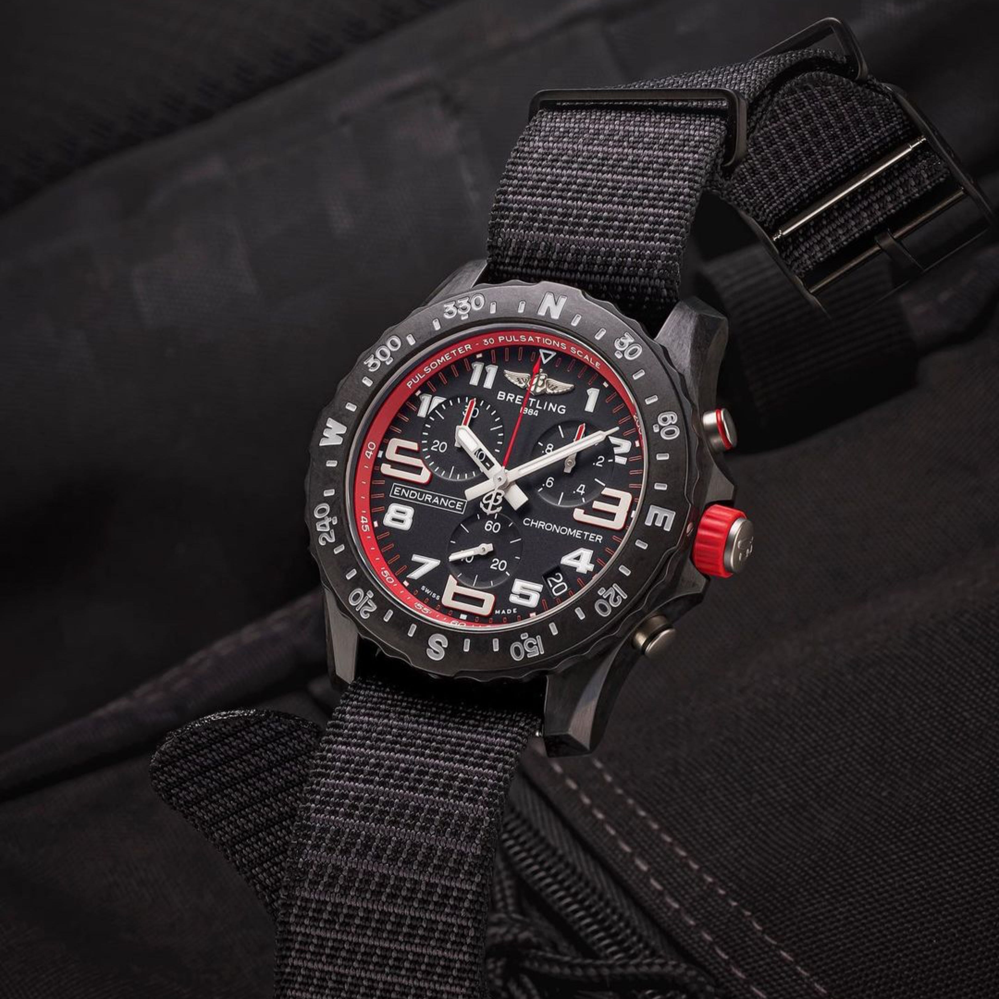 Breitling dial paired with a Black X-Hatch RSM Watch Strap, displayed against a sleek black fabric background for a bold, stylish look.