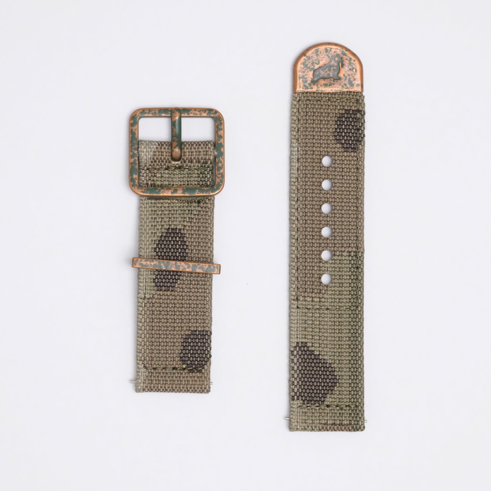 A jacquard woven IRR camo strap from RSM with 5 colored yarns, distressed bronze buckle, keeper, and Walrus stamped end cap, with a greenish patina.