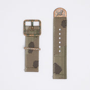 A jacquard woven IRR camo strap from RSM with 5 colored yarns, distressed bronze buckle, keeper, and Walrus stamped end cap, with a greenish patina.