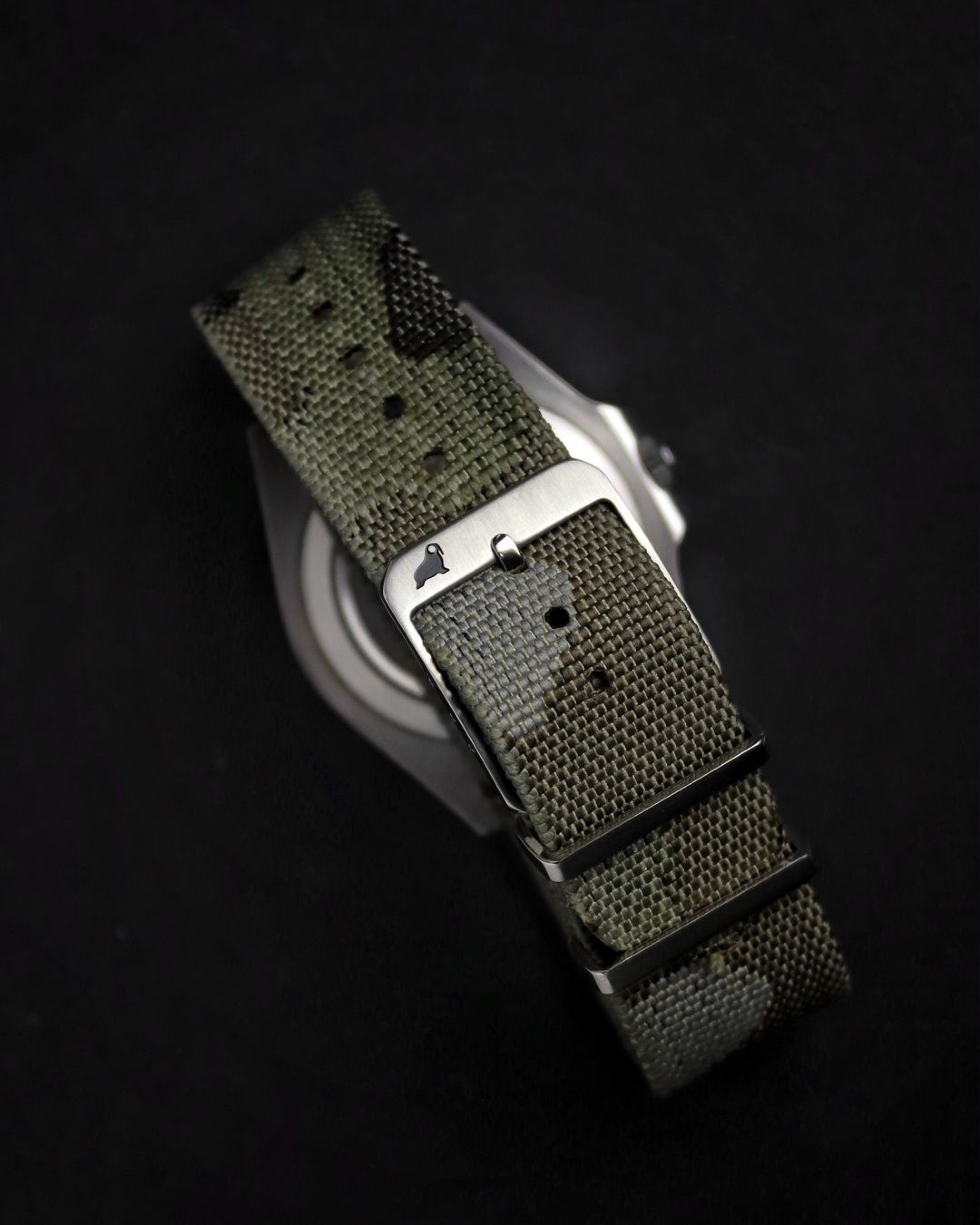 Camouflaged watch band with pre dyed jacquard woven pattern. 316L stainless steel buckle in brushed finish with black Walrus RSM logo in black background. Camouflage strap has 5 different colored yarn in gray, dark brown, light green, dark green and brown colors.