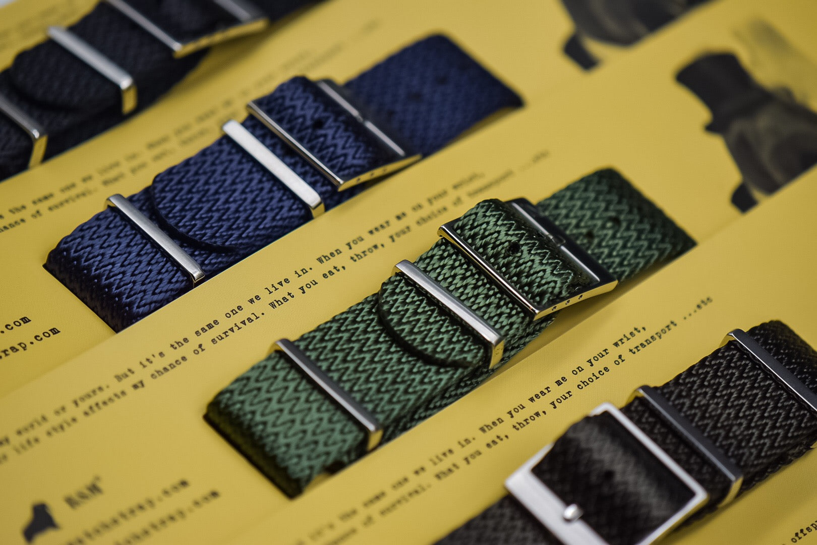 Herringbone woven watch straps by RSM in green, blue, brown, and black with 316L stainless steel hardware. Packaging and Walrus logo in background.