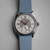 The Fears Brunswick 38 Topper Edition 'Silver Sector' in 38mm, paired with RSM's Light Blue Fine Canvas watch strap, offers a fun, casual look for any occasion.