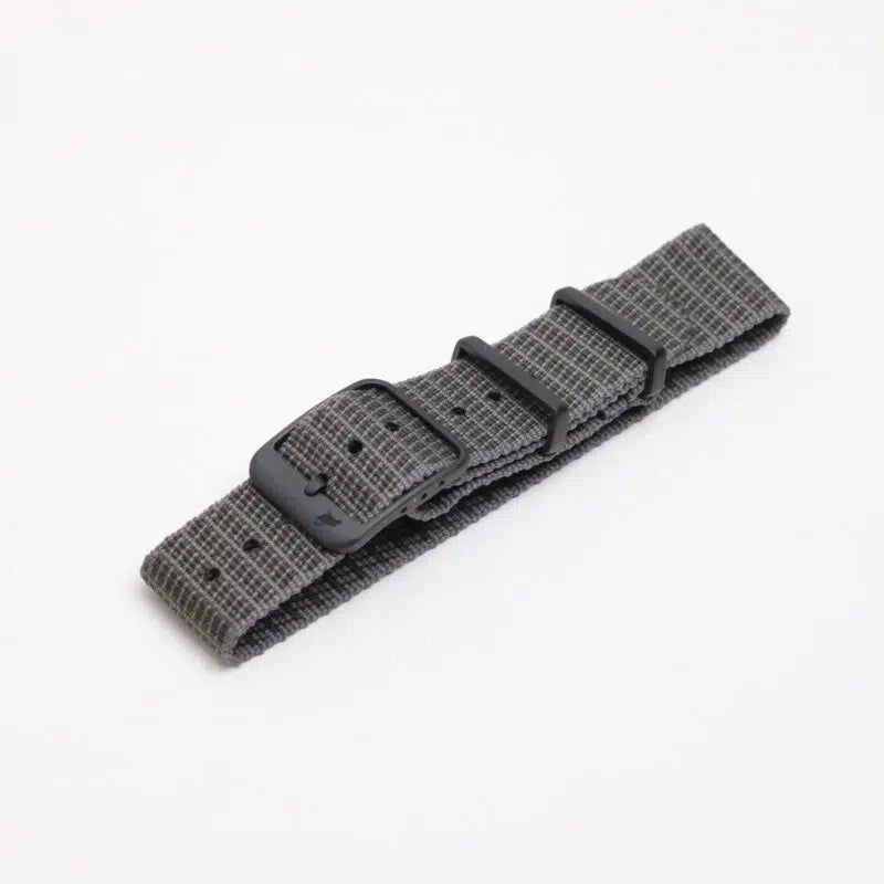 The RSM X-Hatch green nylon watch strap features a textured checkered design, a black buckle, and two loops, displayed on a white background.