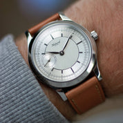 Habring2 Felix with a vertical brushed texture dial and second-hand subdial at 9 o'clock is paired with RSM's Buttero Biscotti tan leather strap, worn with a grey jumper.