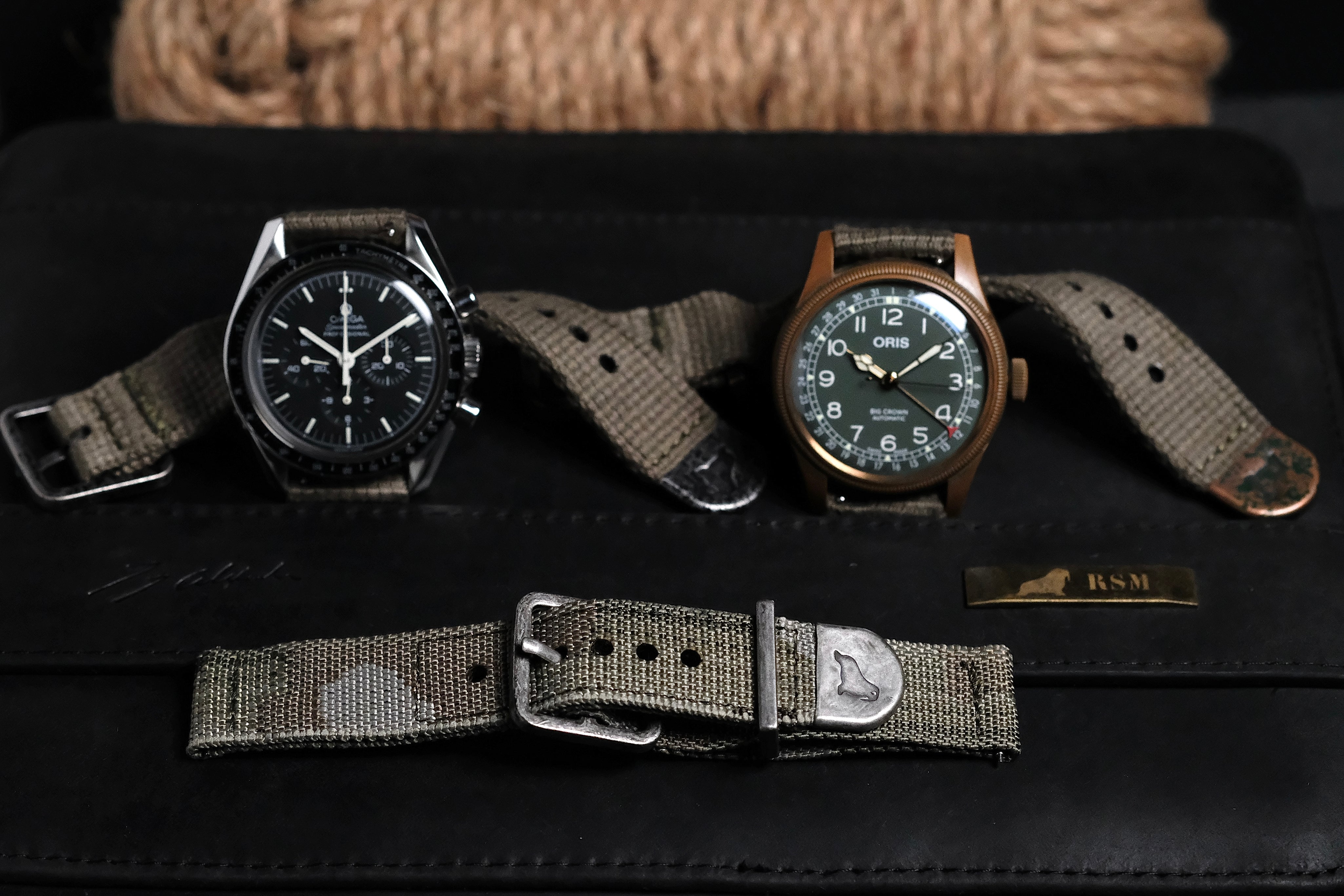 Vintage green and camo watch bands with distressed hardwares. Matches with watch collection. Poly cotton olive drab colour with distressed black, distressed bronze hardwares fitted on Omega Speedster and Oris Brig Crown Pointer Dater in bronze case and been dial. Jacquard woven camouflaged IRR watch strap with silver distressed hardware.