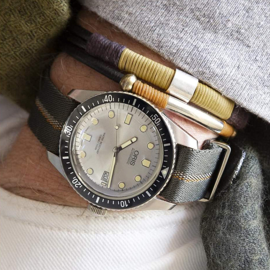 Wrist shot of the Oris Diver with silver dial, worn with matching bracelets and RSM's Engraved Stripe watch band.