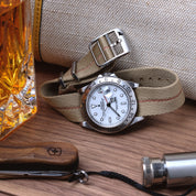 Rolex Explorer II paired with Red Cross Stripe Engraved RSM Watch Strap, placed on a wooden table with Swiss tools nearby.