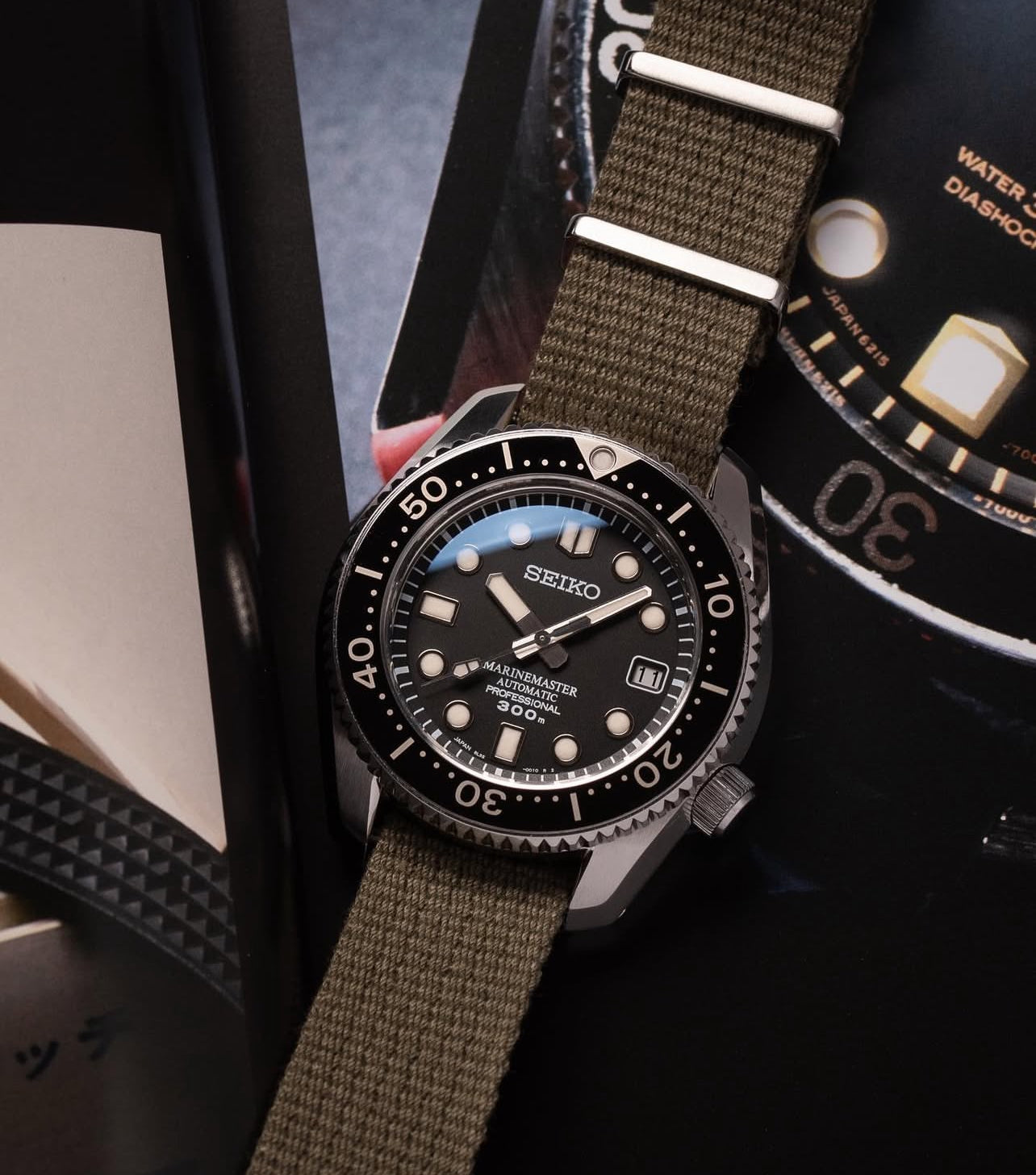 Seiko Marine Master SBDX001 with RSM's vintage military green single pass poly cotton watch band with adjustable length to fit wrist sizes. Watch and strap placed against marine master enlarged detail.