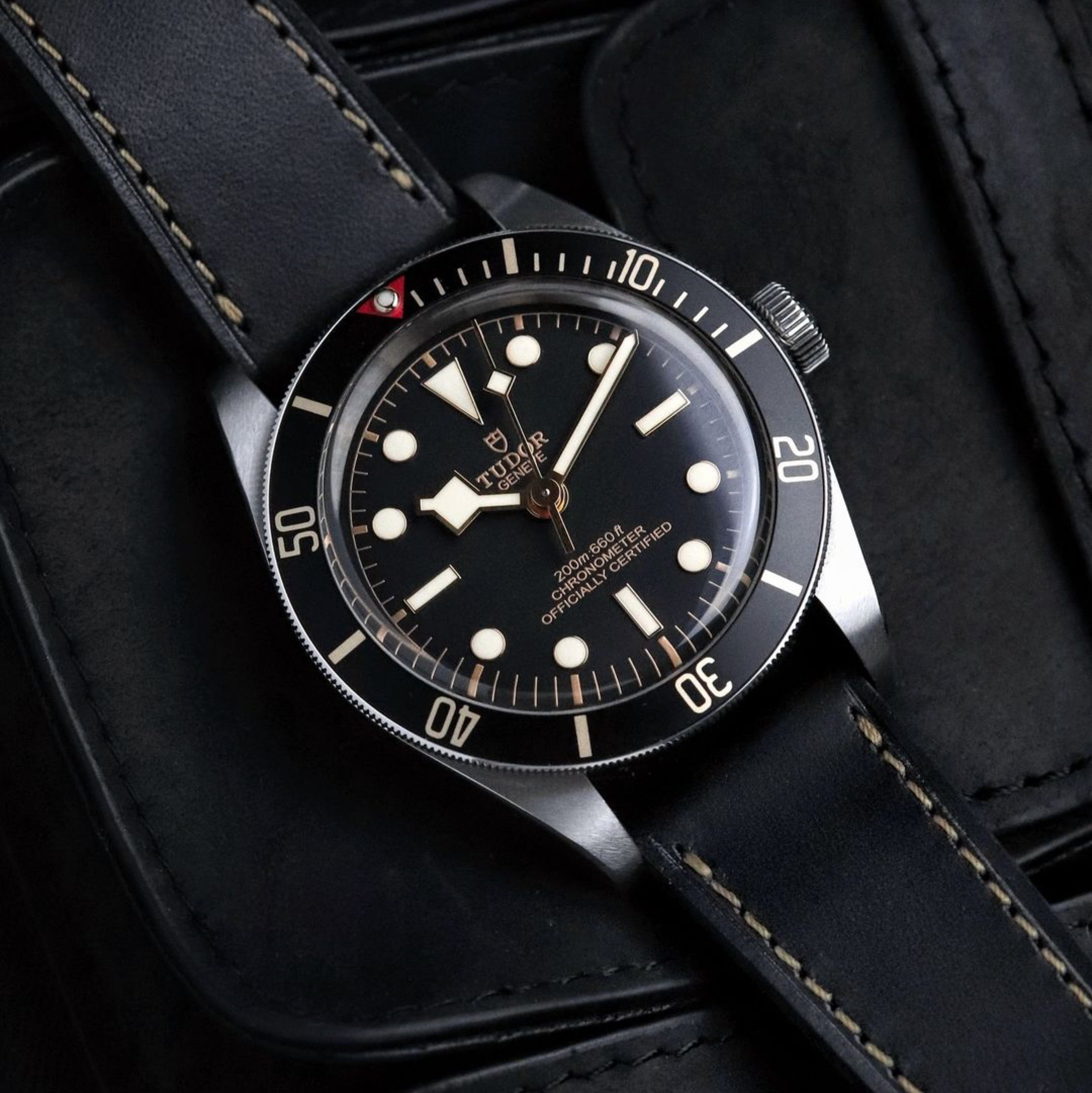 RSM Raven Black Buttero leather strap on the Tudor BB58 with a gilt dial and beige stitches. Set against black leather pouches, this combo exudes sophistication.