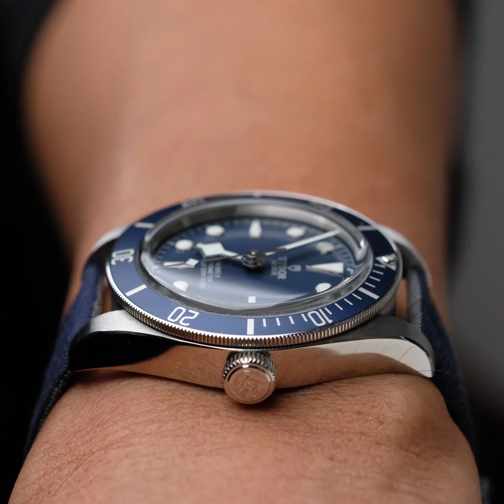 A silver watch with a blue face and bezel, paired with RSM’s Blue 2-Piece Silk Strap with Grey Lining, showcasing luminous hands and markers.