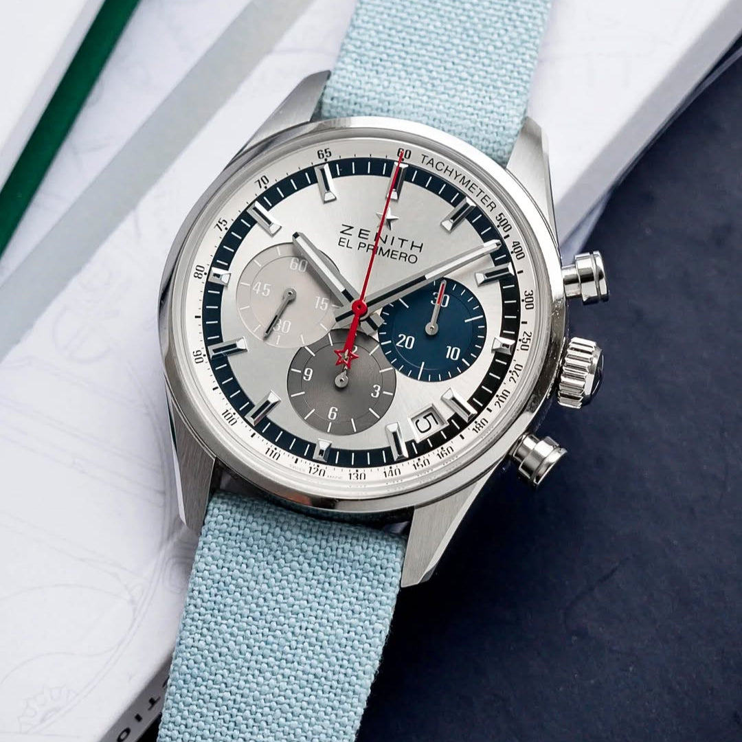 The Zenith El Primero Chronomaster 38mm with RSM's Light Blue Fine Canvas watch strap offers a fresh look, enhancing the red chrono seconds against a book backdrop.