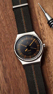 Autodromo watch with orange markers and hands shaped in 70's style matches well with RSM's single pass strap in dark green with orange center stripe.